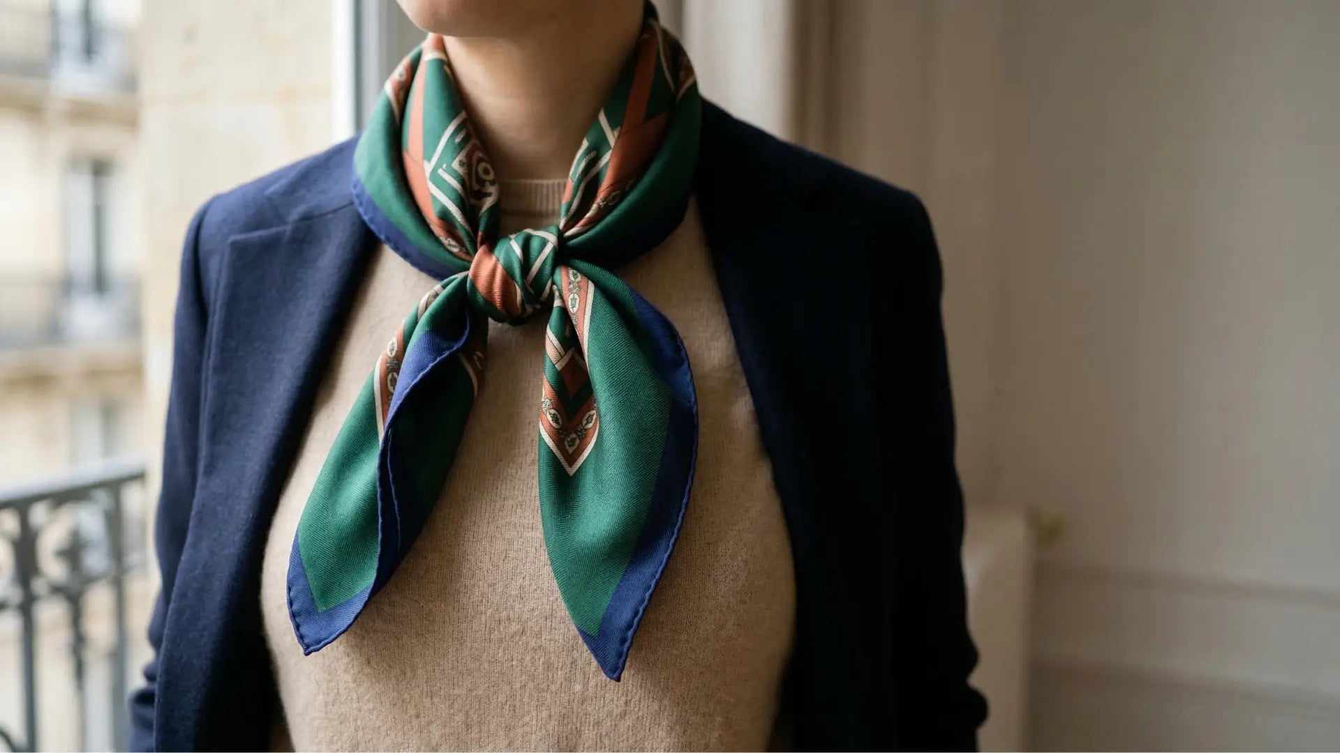 Vibrant green blue geometric silk scarf elegantly tied around neck Image