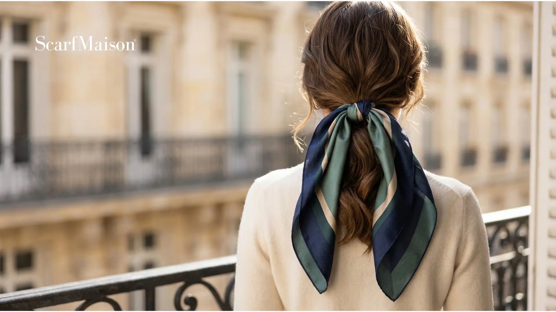 Back view of navy and teal striped silk scarf tied in bow at nape of neck Image