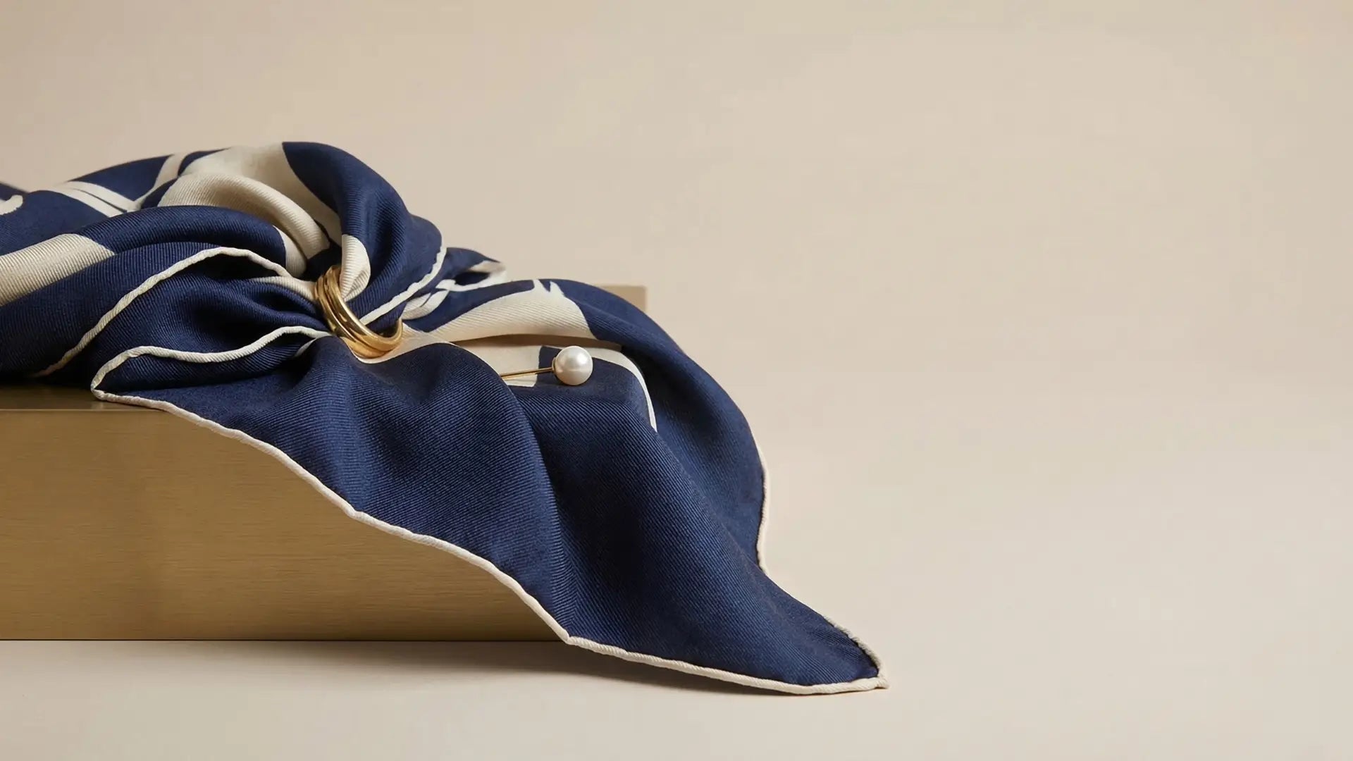 Navy blue silk scarf with cream geometric patterns in How to use a scarf article Image
