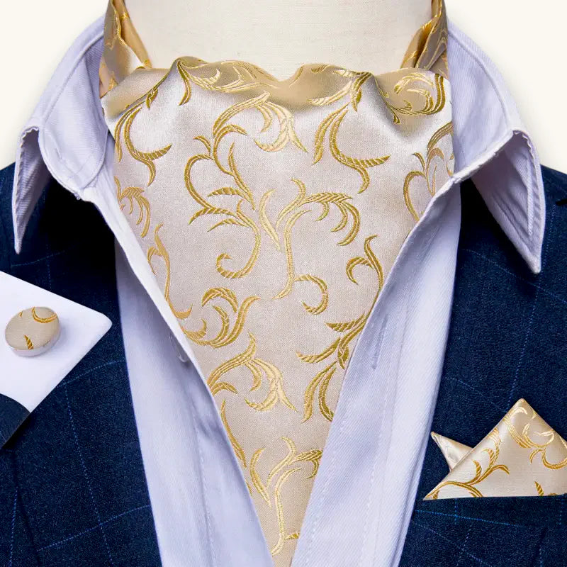 Luxurious beige ascot cravat with intricate gold leaf patterns on satin fabric