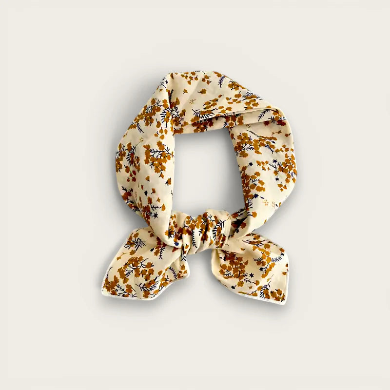 Cream-colored silk scarf with mustard yellow navy floral pattern, elegant knot