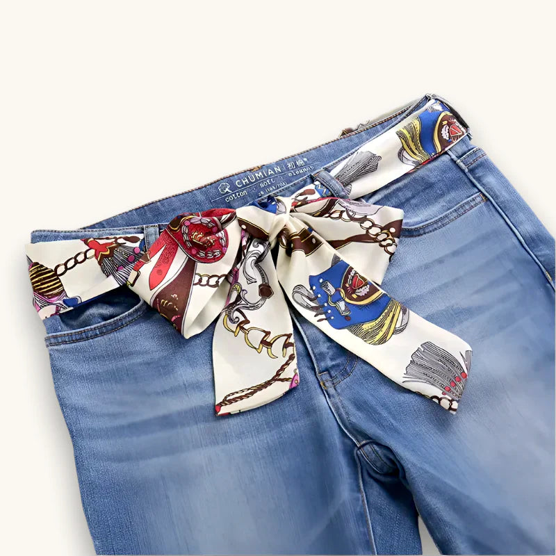 White silk scarf with vintage horse and chain print tied as belt on jeans