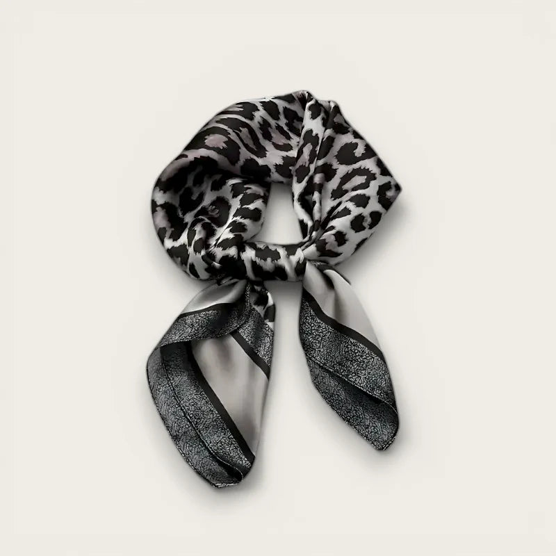 Sleek black leopard silk scarf with silver stripes, elegantly knotted
