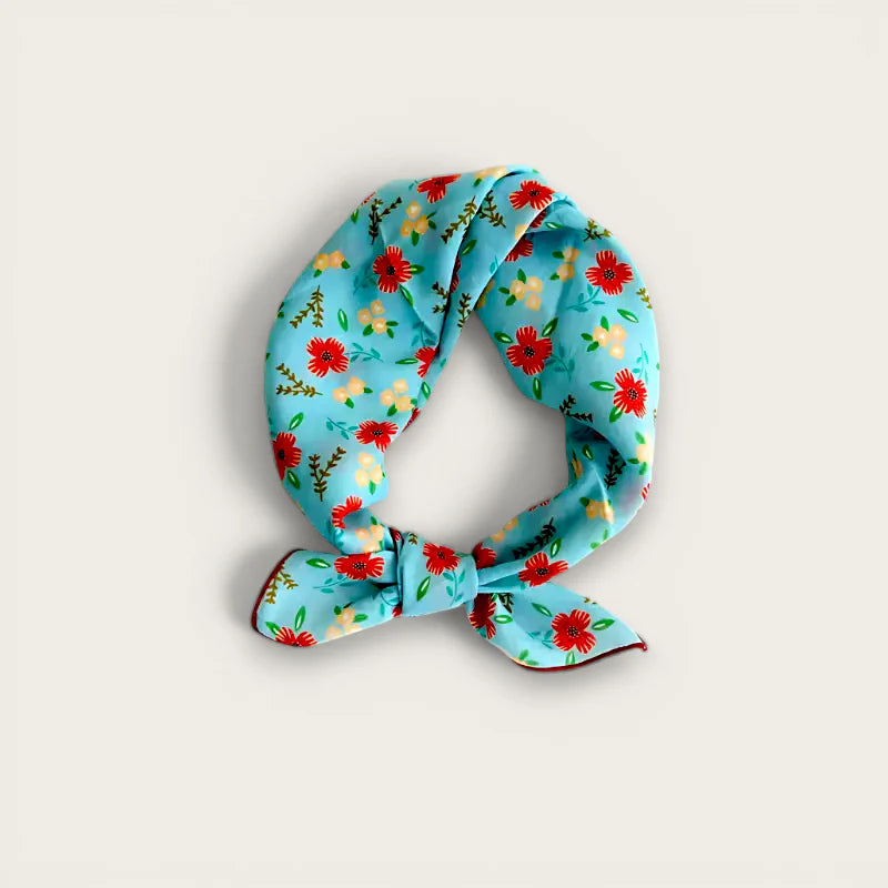 Light blue silk scarf with red yellow green floral pattern in knot