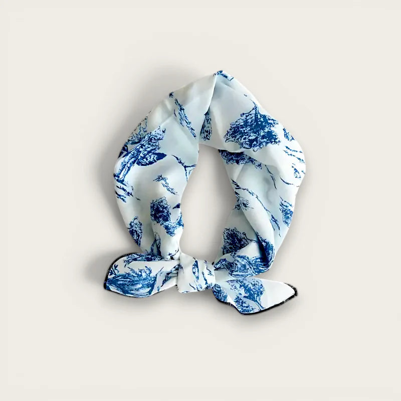 Blue and white cotton scarf with toile pattern tied in neat knot