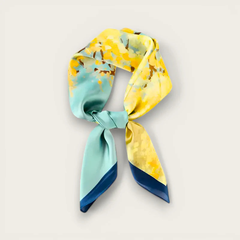 Blue and yellow silk scarf with vibrant teal abstract pattern in elegant knot