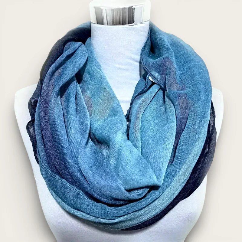 Blue infinity scarf with soft gradient, subtle texture, sheer edges