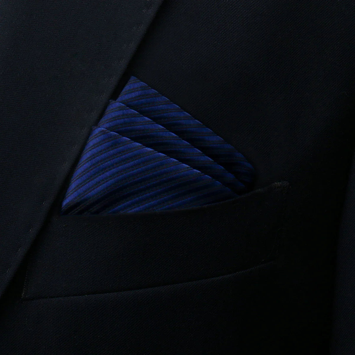 Blue pocket square with diagonal ribbed texture in navy suit pocket