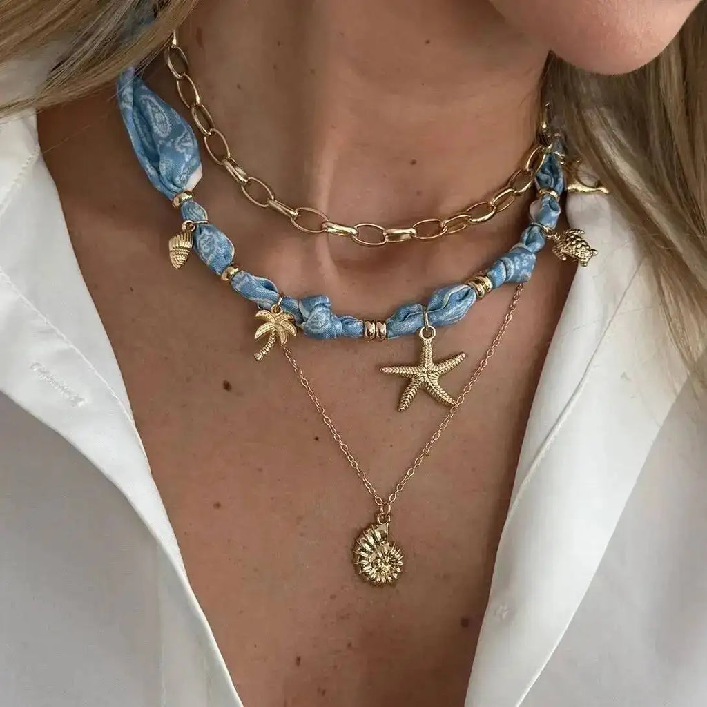Blue Scarf Necklace with gold layers, seashell charms, and starfish pendant