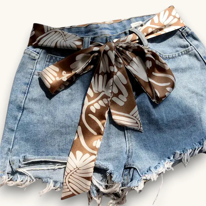 Brown scarf belt tied as bow on denim shorts waist