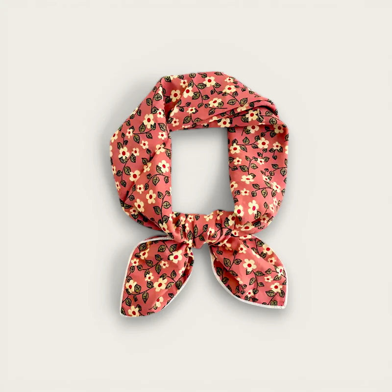 Pink floral cotton scarf tied in neat knot with white-trimmed ends, summer style