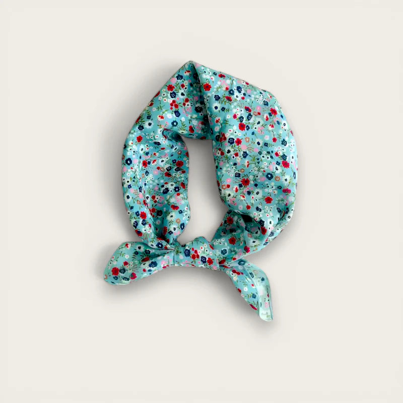 Light blue silk scarf with red pink navy floral pattern in neat knot