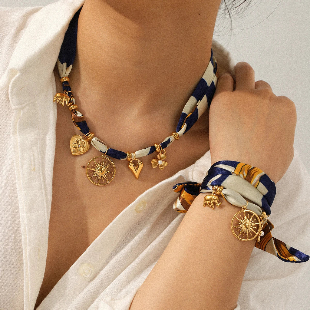 Gold scarf necklace with sun elephant charm and navy cream silk ribbon