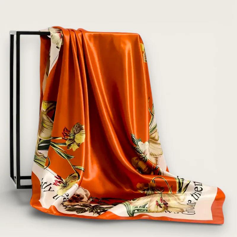 Large orange silk scarf with vibrant floral print and cream accents