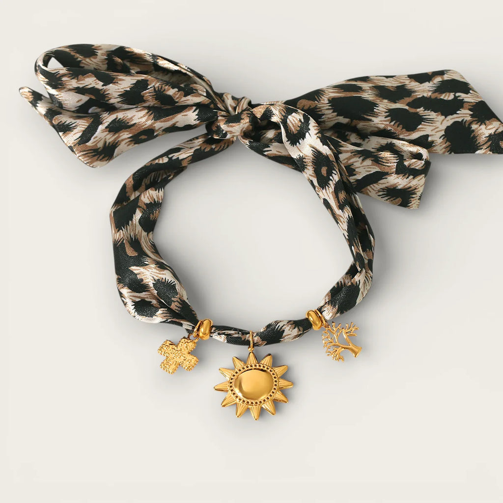 Leopard-print silk scarf necklace with gold sun tree cross charms in bow
