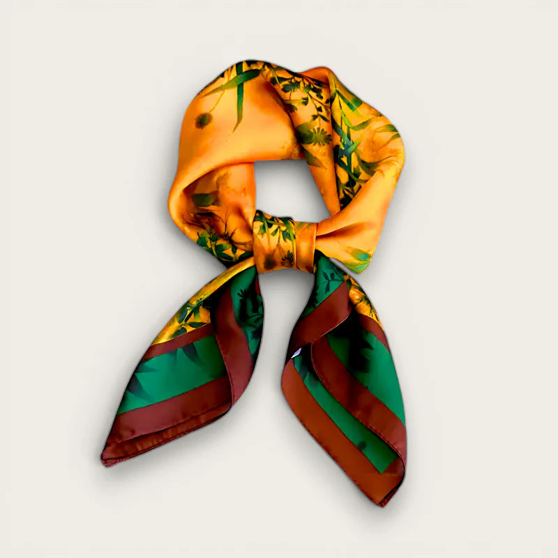 Luxury silk scarf in vibrant orange with botanical print and green-brown edges