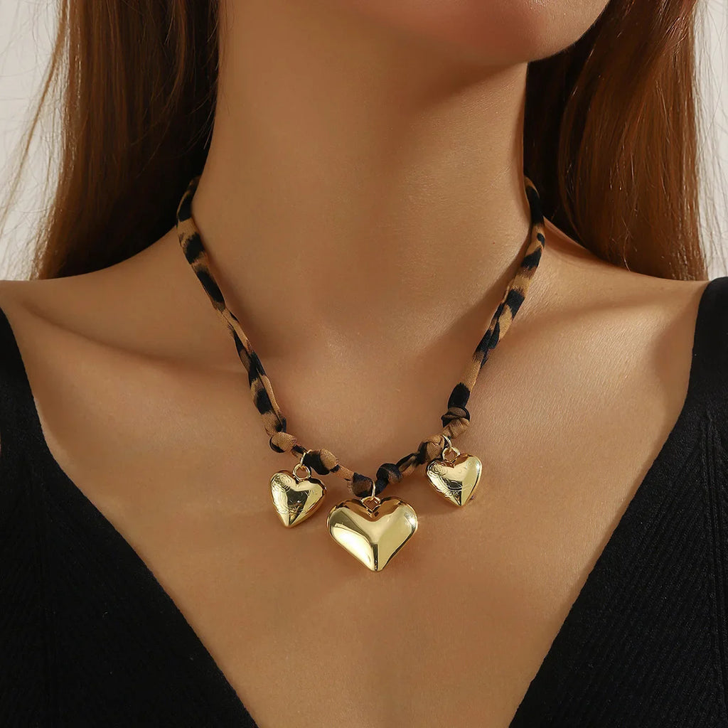 Maroon scarf necklace with gold heart pendant on leopard cord