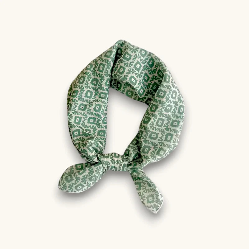 Mint green silk scarf with dark green geometric pattern, neatly knotted
