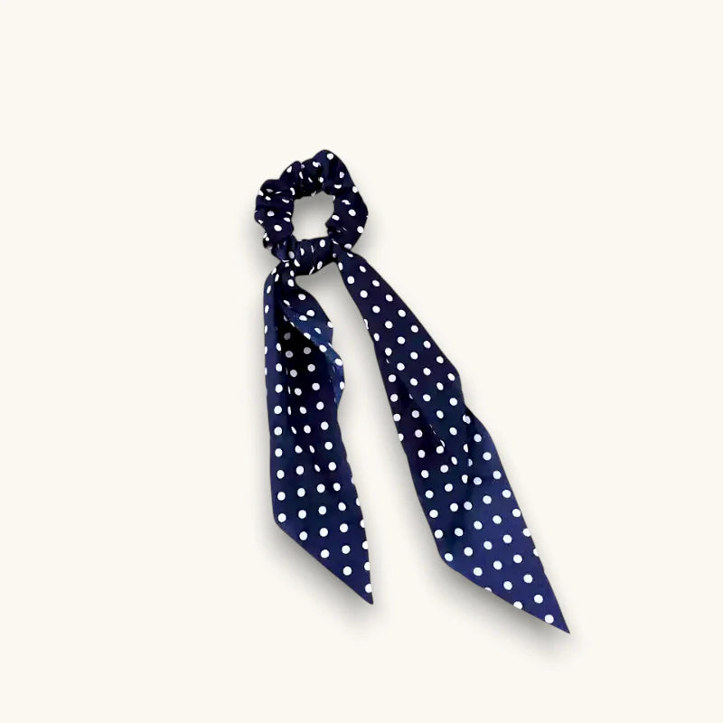 Navy blue silk scrunchie with white polka dots and flowing ribbon tail