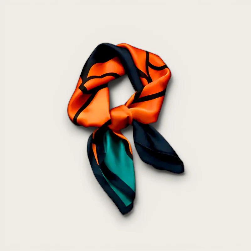 Vibrant orange and teal silk scarf with bold black line art in stylish knot