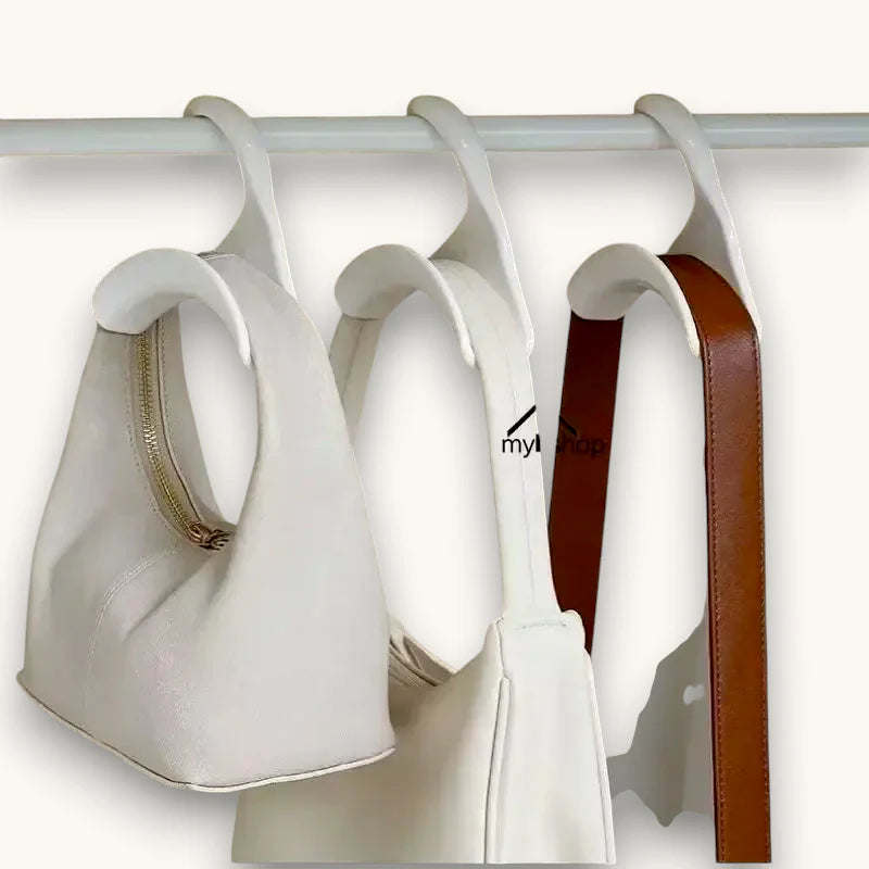 White leather handbag with gold zipper and brown strap on plastic scarf hanger