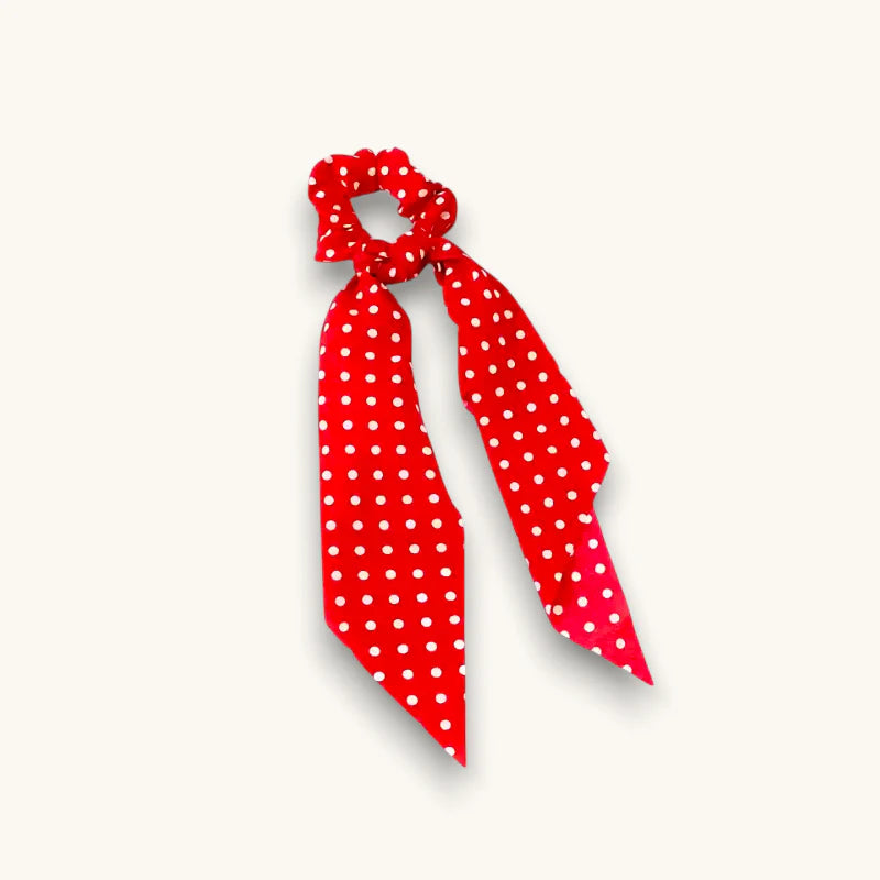 Red polka dot bow scrunchie with white dots and tied ribbon tail