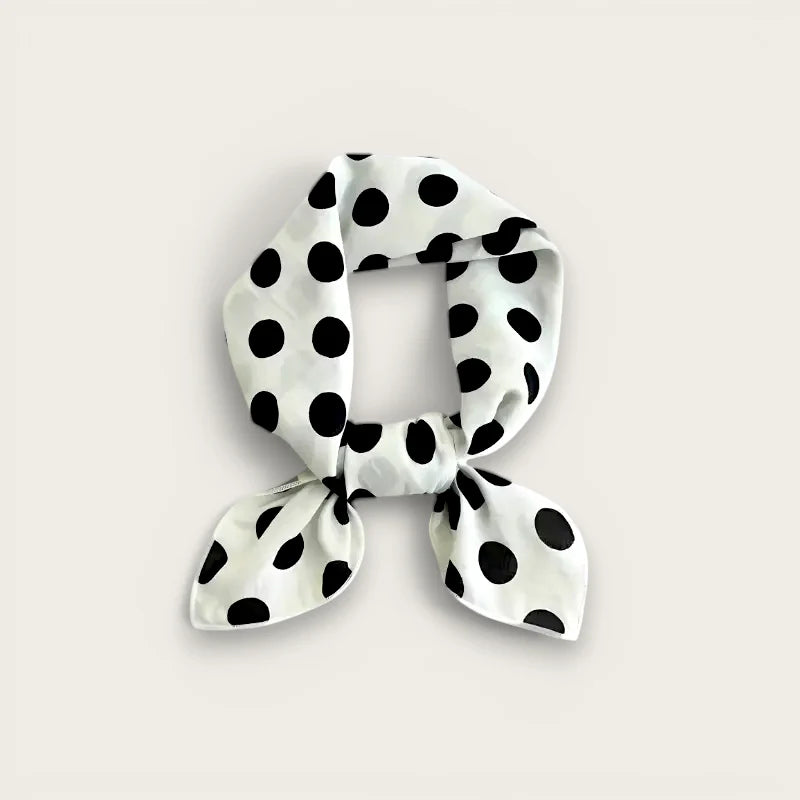 Polka dot cotton scarf in white silk with bold black dots, neatly knotted