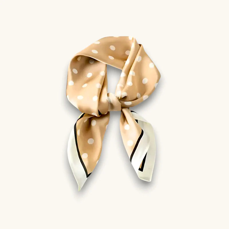Polka dot silk scarf in beige with white dots and black trim, elegantly knotted