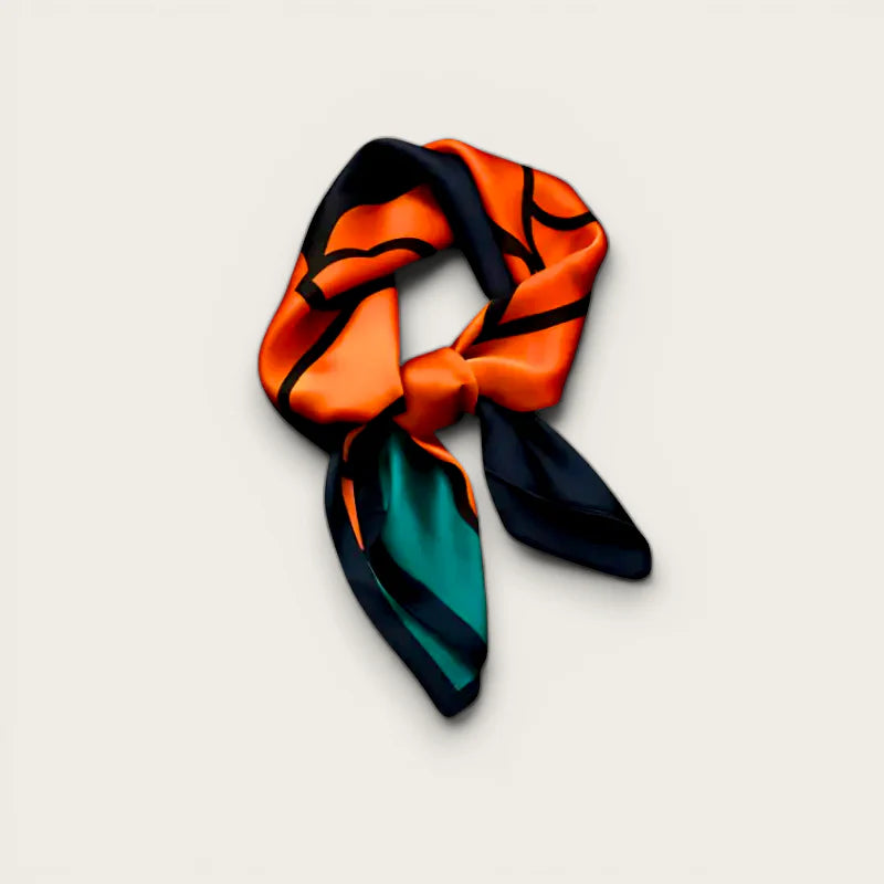 Vibrant orange and teal silk scarf with bold black outlines in neat knot