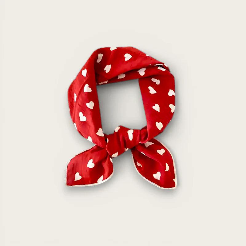 Red silk scarf with white hearts pattern tied in bow