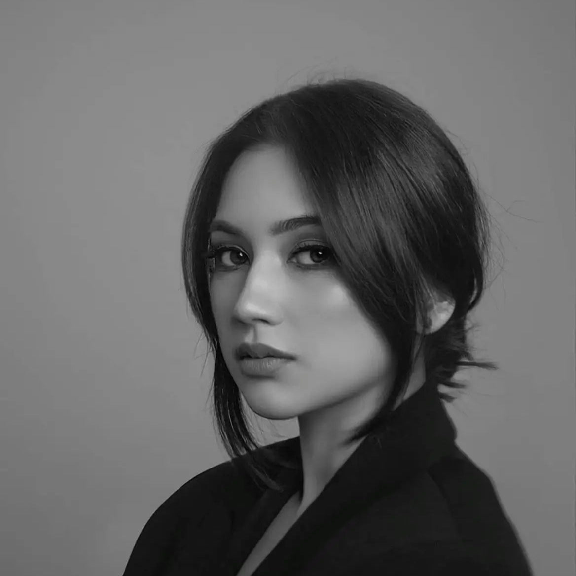 Black and white portrait of a woman with short hair against a plain background