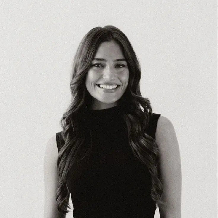 Black and white photo of a woman with long hair against a plain background