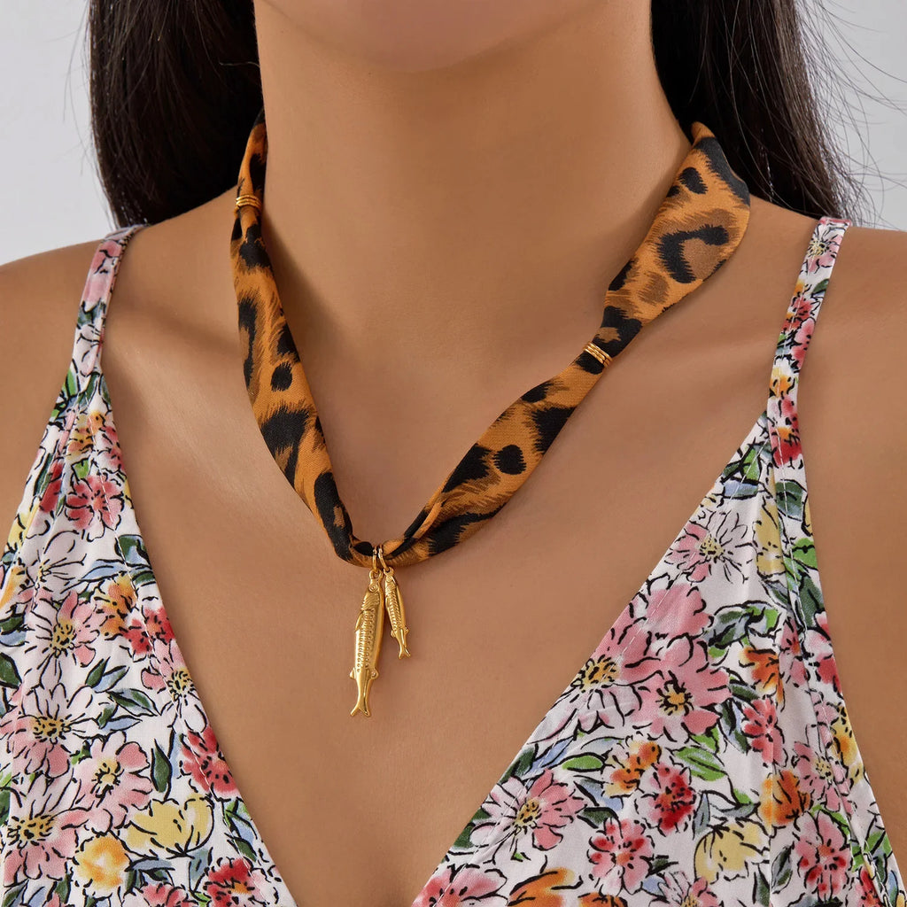 Scarf necklace with leopard-print design and gold fish charms