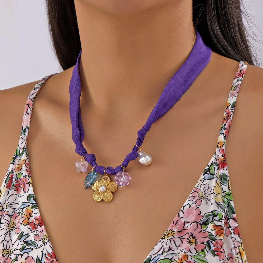 Purple silk scarf necklace with gold flower pendant and crystal charms