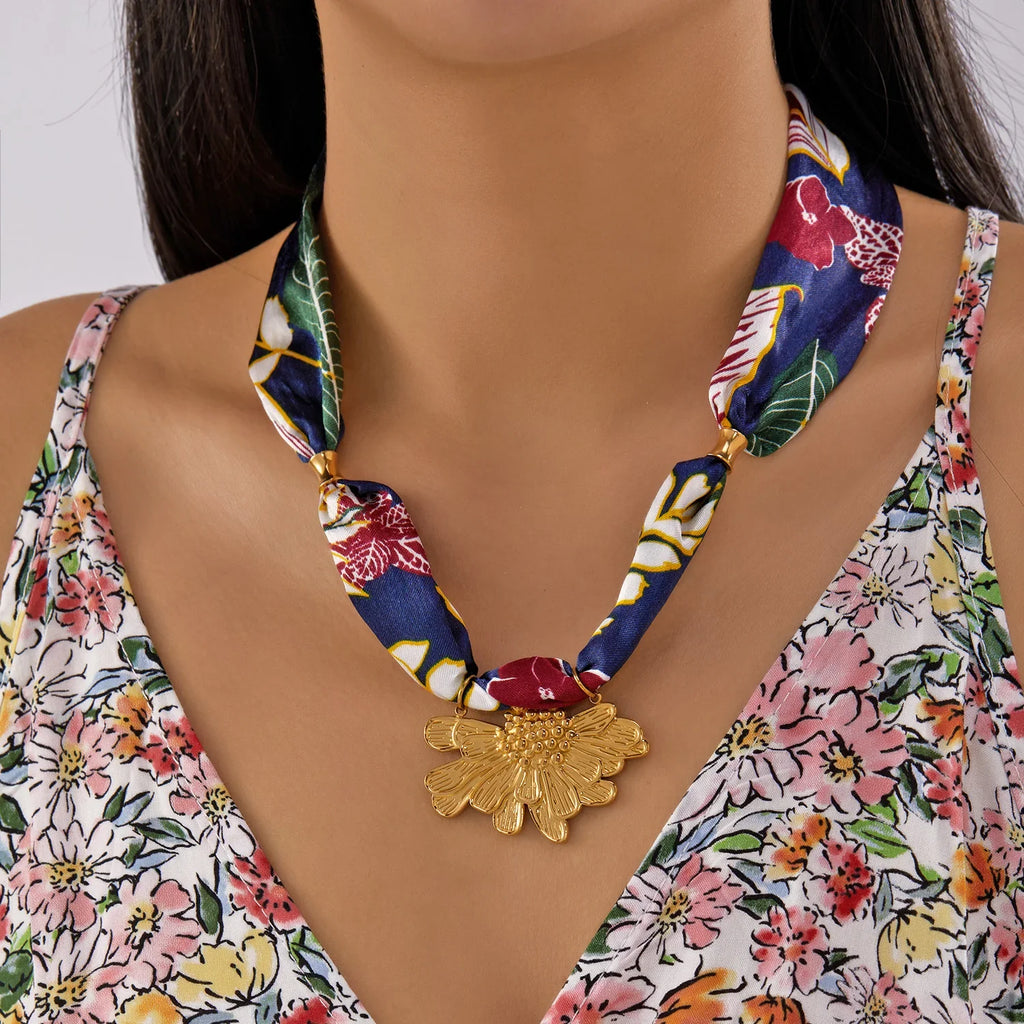 Vibrant blue silk scarf necklace with gold-toned floral pendant charm