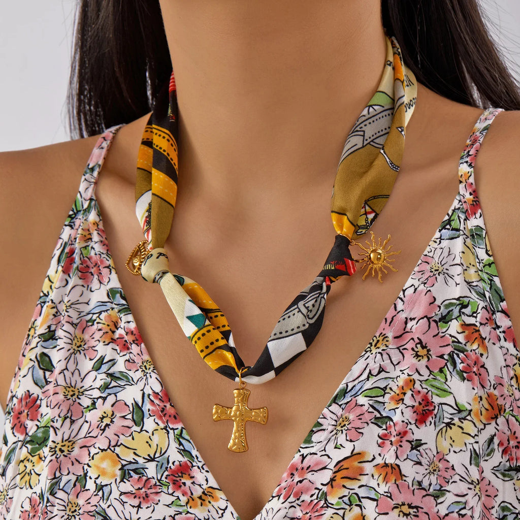 Vibrant patterned silk scarf necklace with gold cross and sun charms