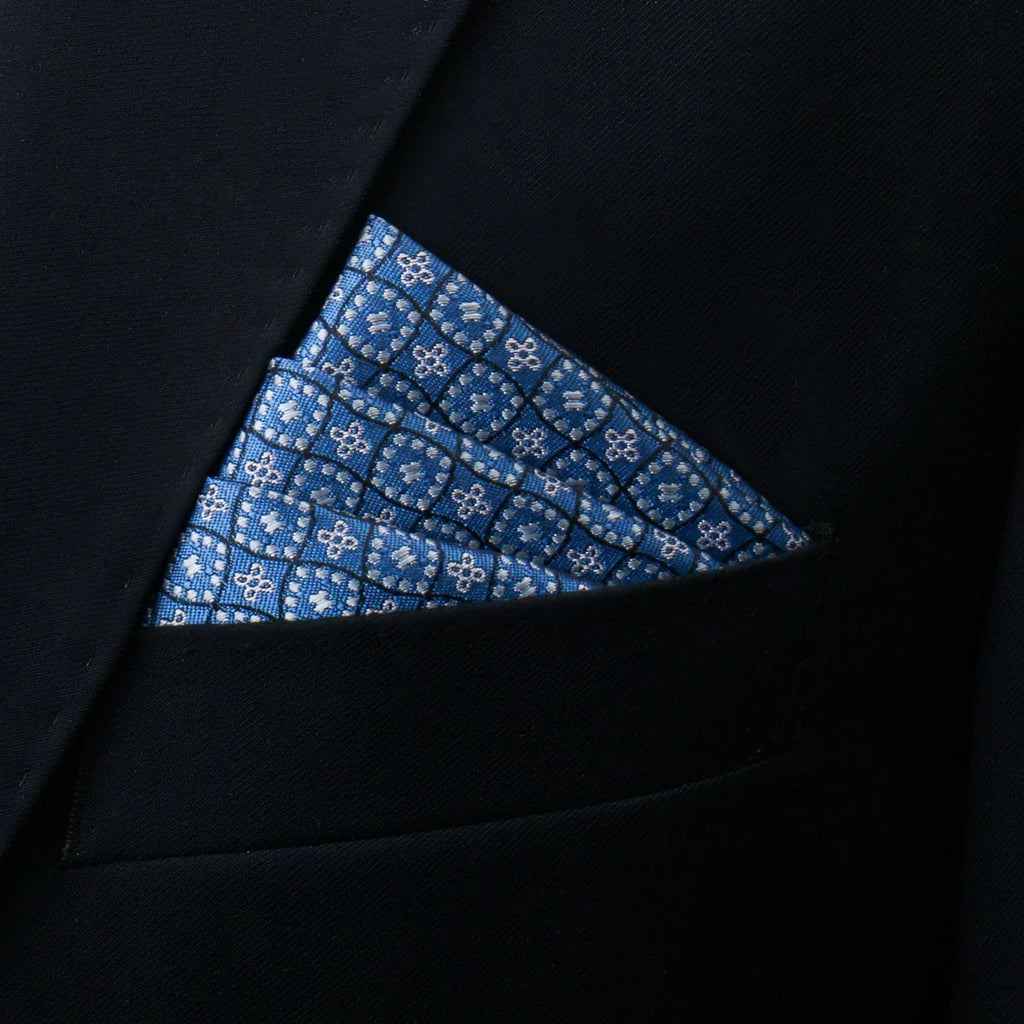 Blue patterned silk pocket square with white floral and geometric designs