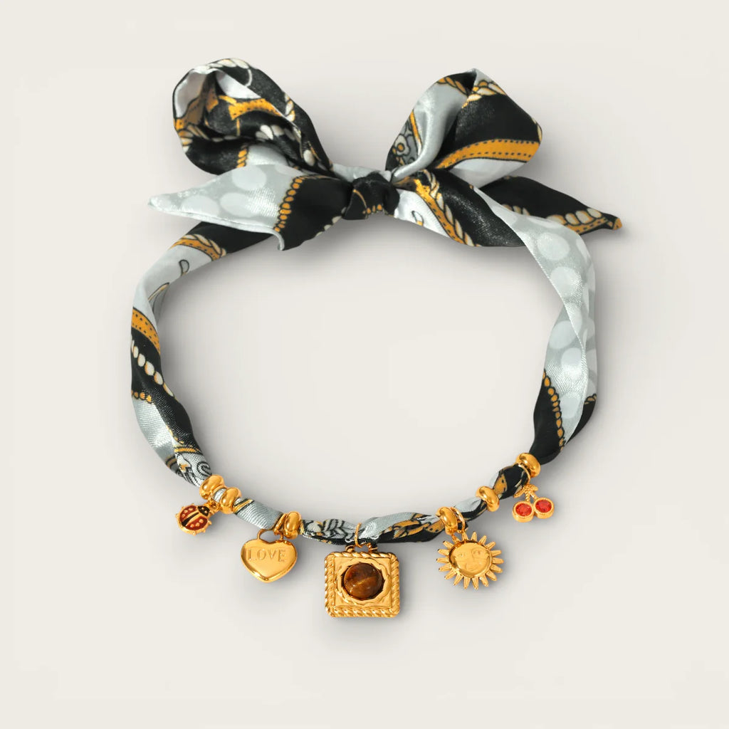 Delicate gold charm bracelet with silk ribbon bow and tiger’s eye pendant