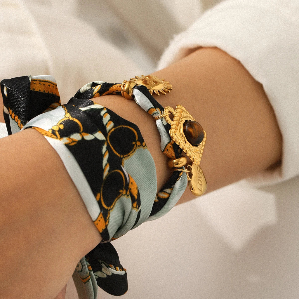 Gold-toned lion and eye bracelet on Silk Scarf Necklace wrist