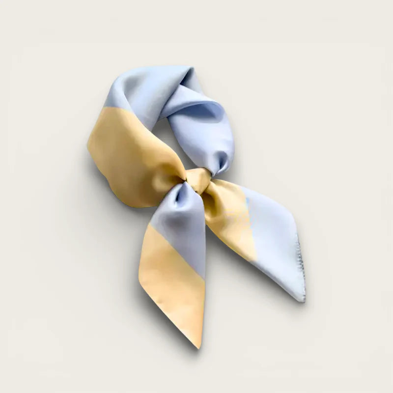Small pastel blue and pale yellow silk head scarf tied in neat knot