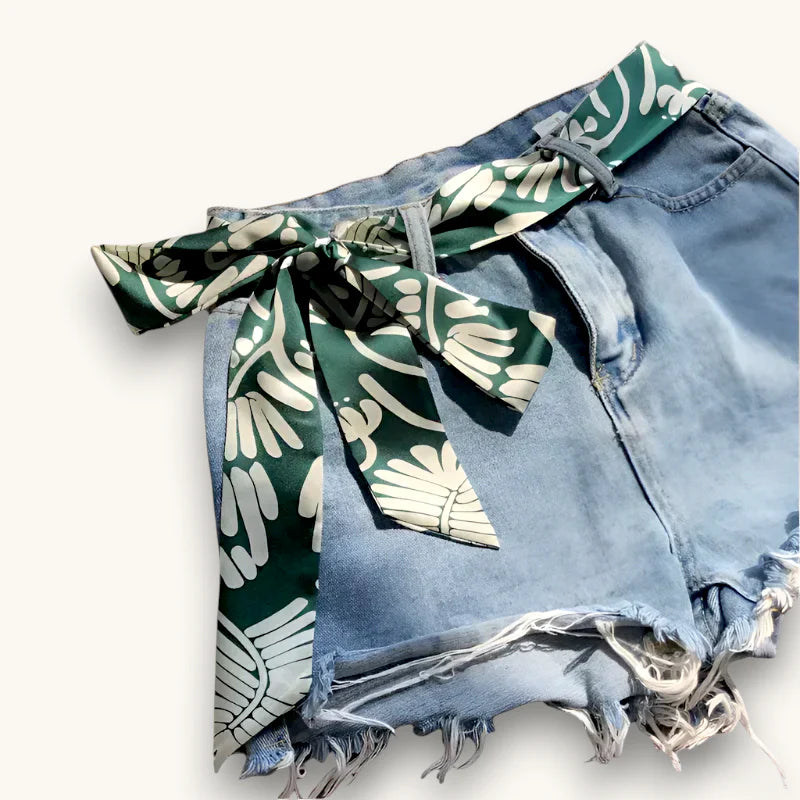 Tropical Scarf Belt: green white silk scarf bow on light-wash frayed denim shorts