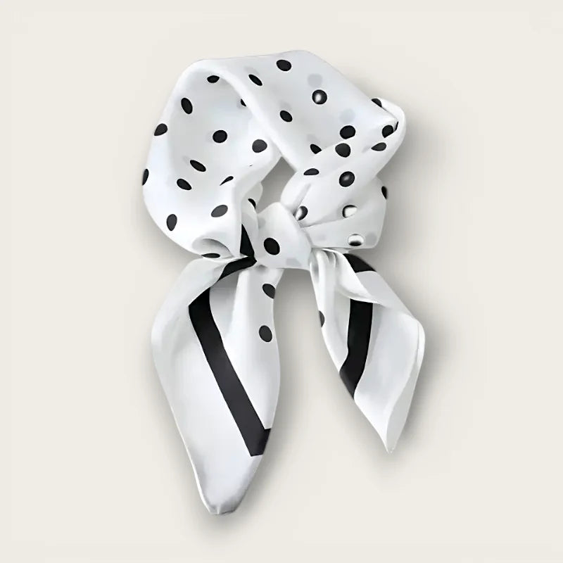 White polka dot silk scarf with black dots and bold stripes, neatly knotted