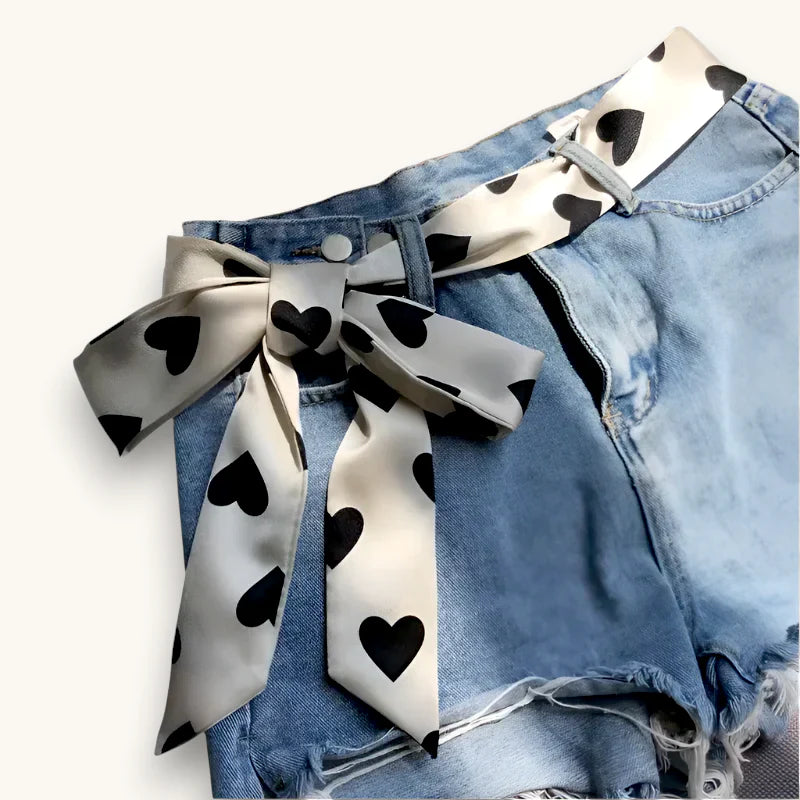 White Scarf Belt: cream satin bow with black hearts on denim shorts