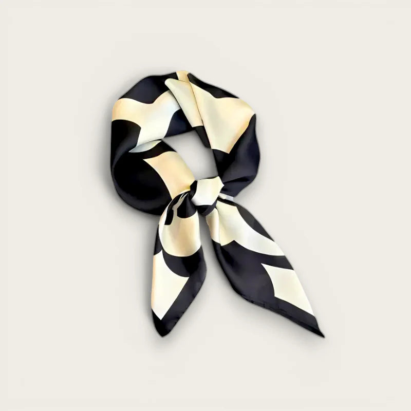 Sleek black and cream abstract patterned silk scarf tied in knot