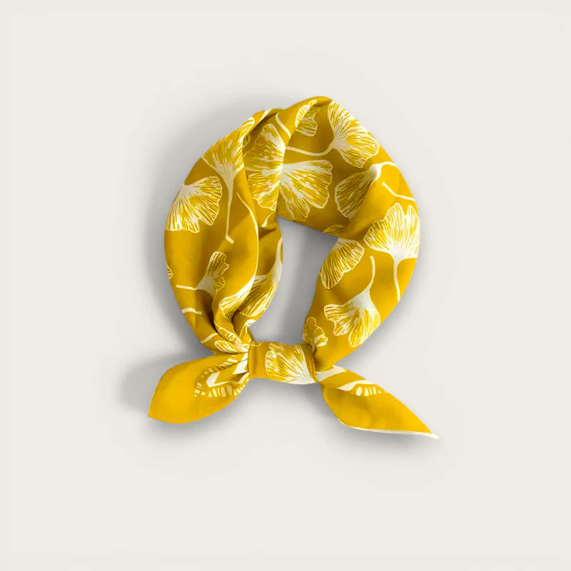 Vibrant yellow silk scarf with white ginkgo leaf pattern in elegant knot