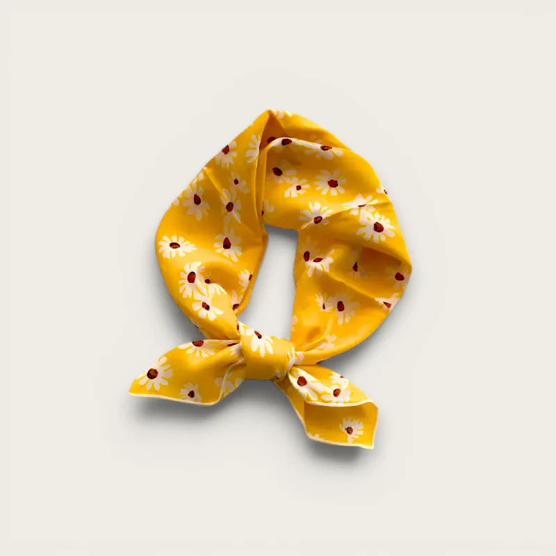 Vibrant yellow cotton scarf with white daisy pattern and red centers, elegant knot