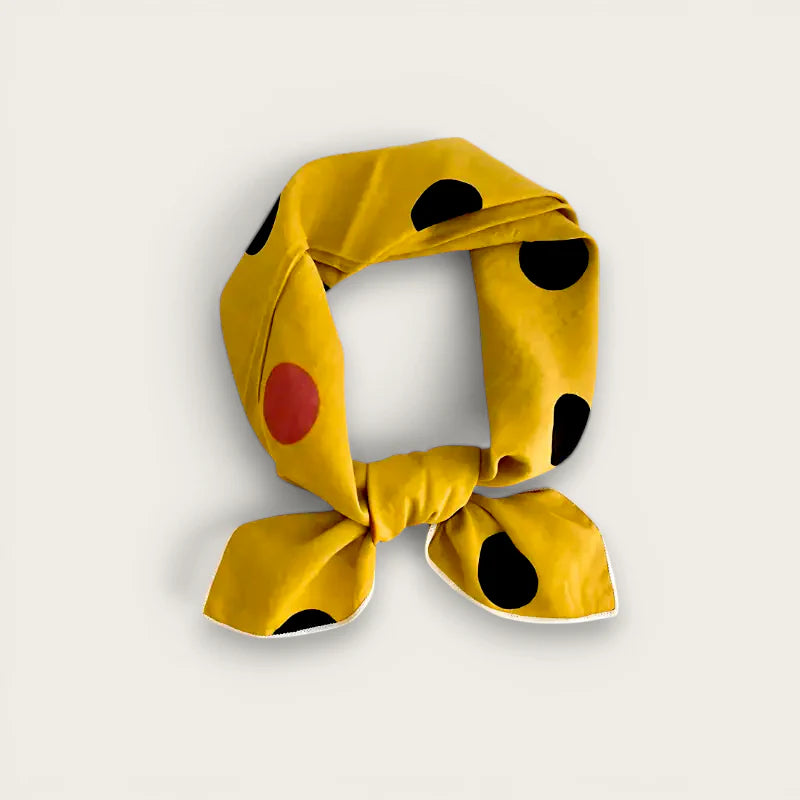 Yellow polka dot cotton scarf with vibrant yellow base, bold black and red dots, neatly knotted